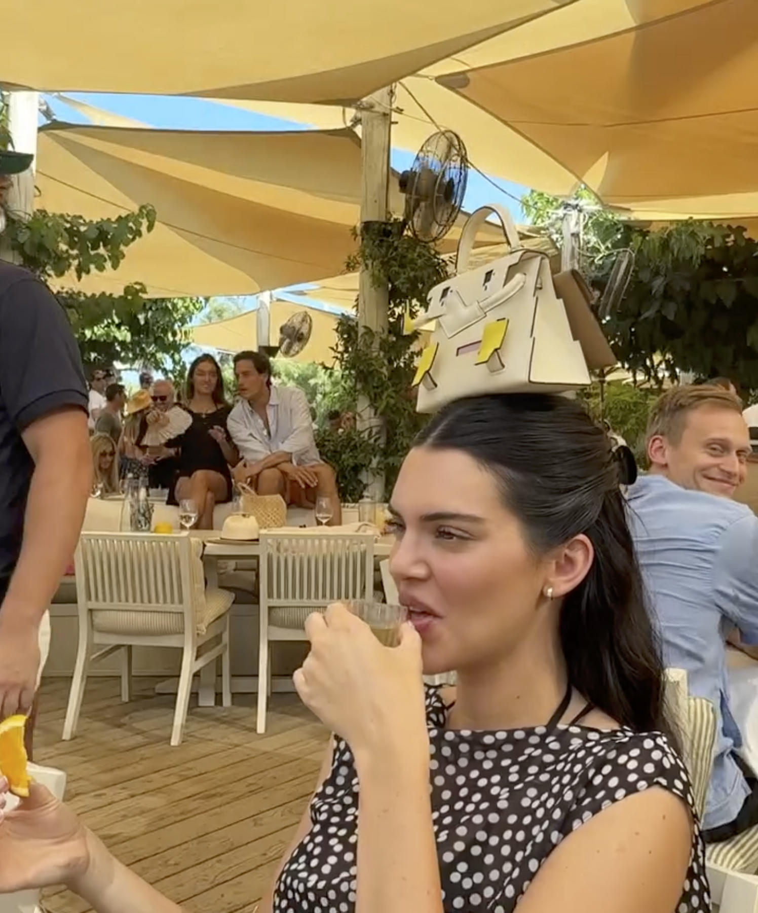 Kendall Jenner takes a shot while balancing $75K handbag on her head after attending ‘tone-deaf’ Bezos wedding